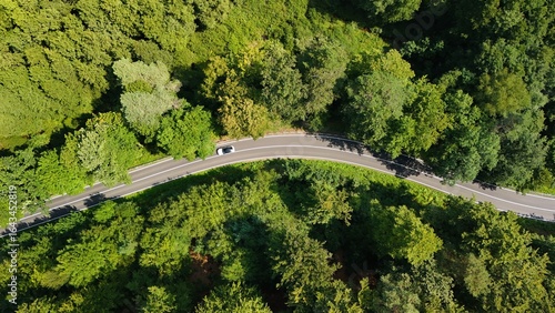 A country road winds through forests and meadows photographed with a drone