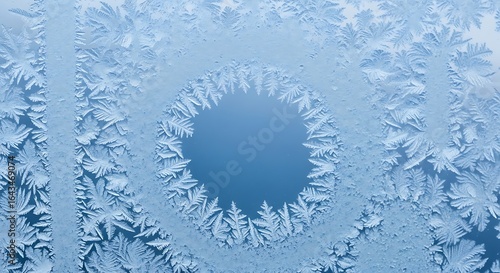 Intricate frost patterns create a mesmerizing winter window display with circular design