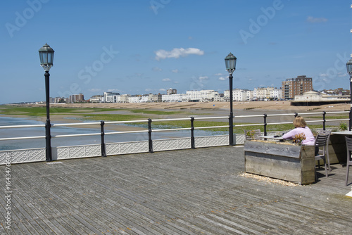 View of Worthing seafront from pier. West Sussex, England. Unrecognisable people.