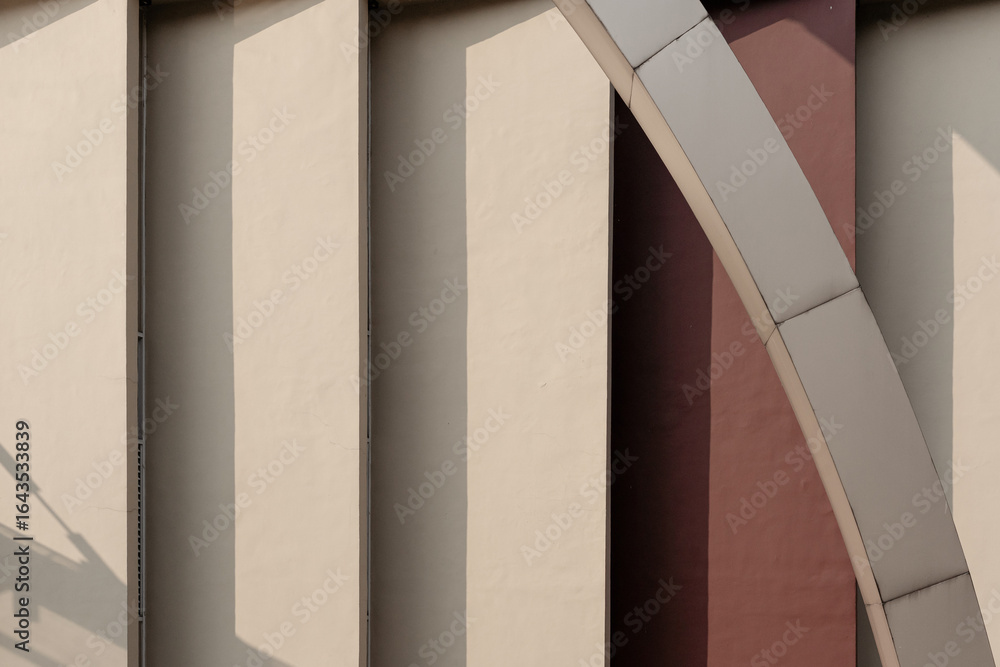 Obraz premium Minimalist abstract photo of modern architecture, showing a play of light and shadow on geometric pillars and a diagonal arch.