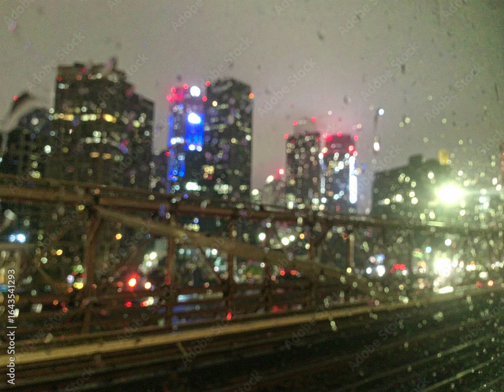 Fototapeta premium Rainy Night Cityscape Viewed from a Train Blurry Lights and Skyscrapers
