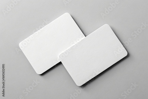 Two blank white rounded corner cards on gray surface