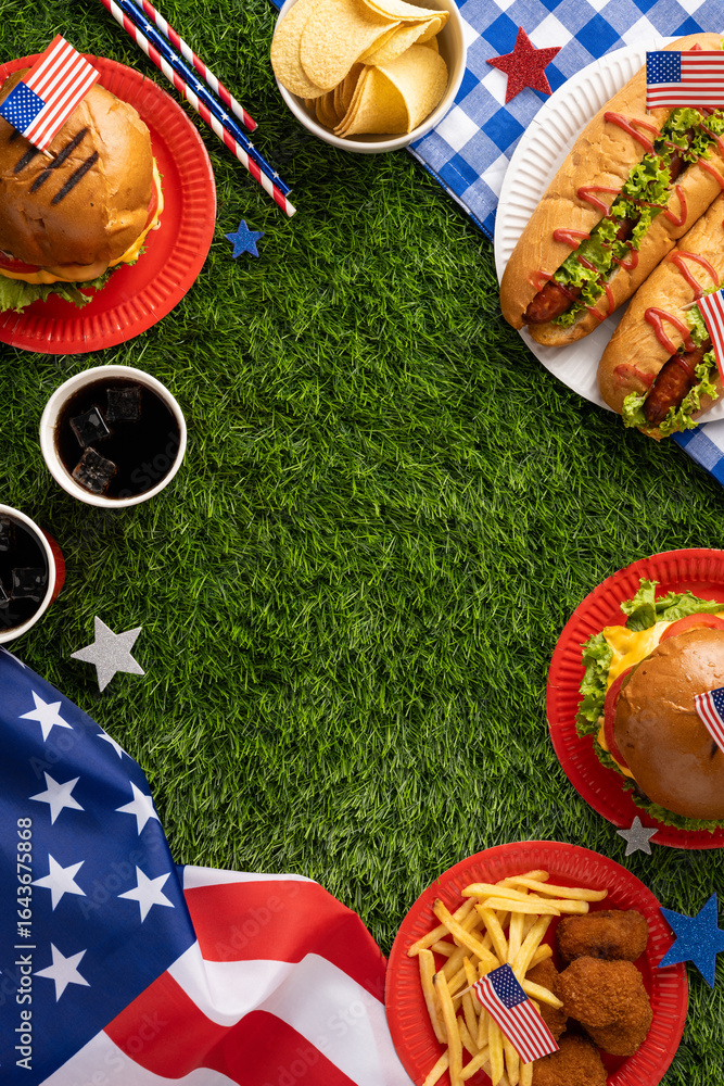 Fototapeta premium Labor Day or Independence Day celebration featuring a picnic vertical setup with classic American food items like burgers, hotdogs, fries, and patriotic elements against a grass background
