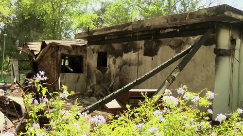 A completely burnt and destroyed house at a southern Israeli kibbutz, where a massive massacre was carried out. few green bush leaves are at the foreground. Kibbutz Nir Oz, Gaza border adjacent.