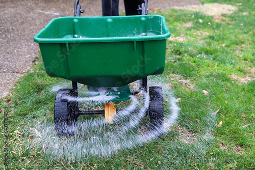 Fototapet A seed and fertilizer spreader sitting out on a lawn