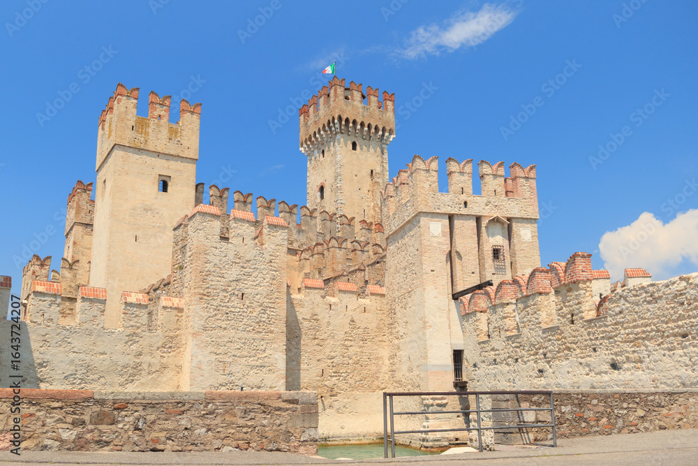 Visitors admire the impressive Scaliger Castle in Sirmione, a stunning example of medieval architecture. The castle stands at the edge of Lake Garda, surrounded by scenic views. Visitors admire the impressive Scaliger Castle in Sirmione, a stunning example of medieval architecture. The castle stands at the edge of Lake Garda, surrounded by scenic views.