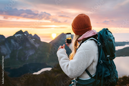 Wallpaper Mural Woman hiking in Norway using smartphone camera in mountains travel blogger tourist with backpack and phone walking in Lofoten islands, active vacation tour outdoor online technology social media share Torontodigital.ca
