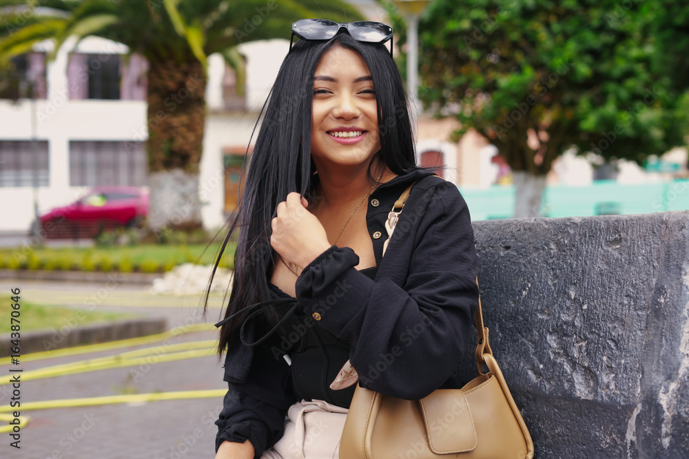 Fototapeta premium Stylish south american woman smiling outdoors in urban setting