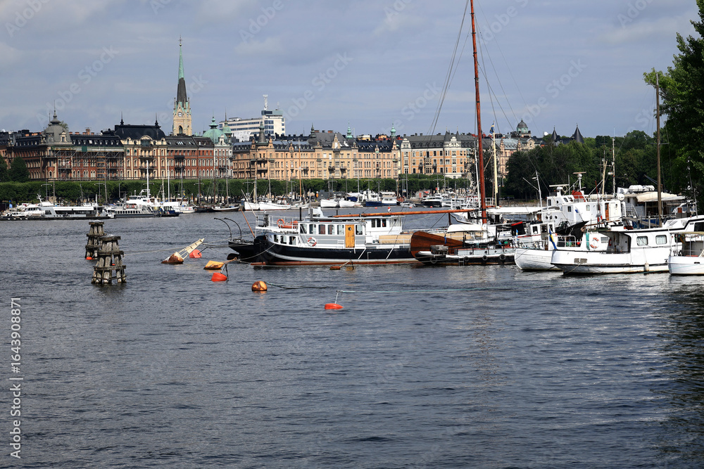 Obraz premium Photo of a waterfront view with historic buildings and boats in the foreground in central Stockholm, Sweden