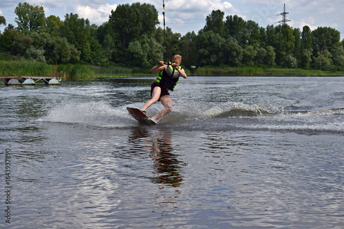 A man is learning to ride a wakeboard.