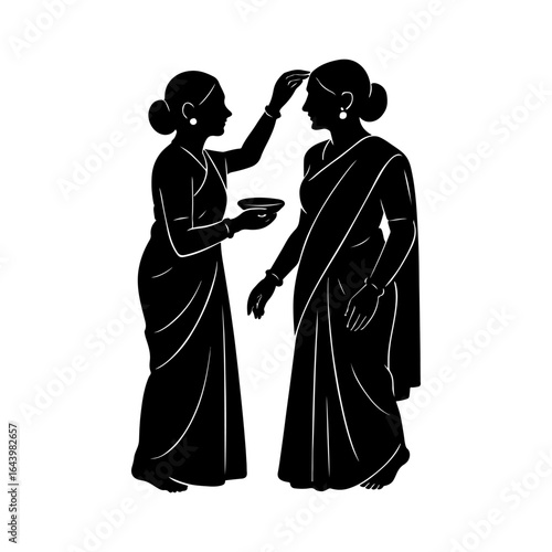 Two women in traditional indian saris applying tilak to each other