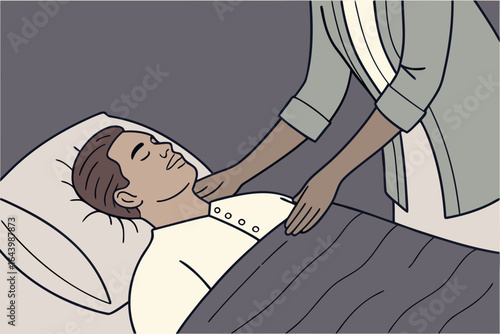Man rests under a weighted blanket during a reiki energy session, practitioner hovering hands calmly.