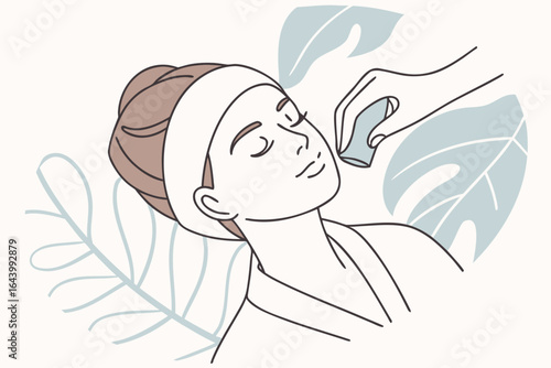 Woman enjoys a gua sha facial massage with smooth jade tools gliding over her cheeks.
