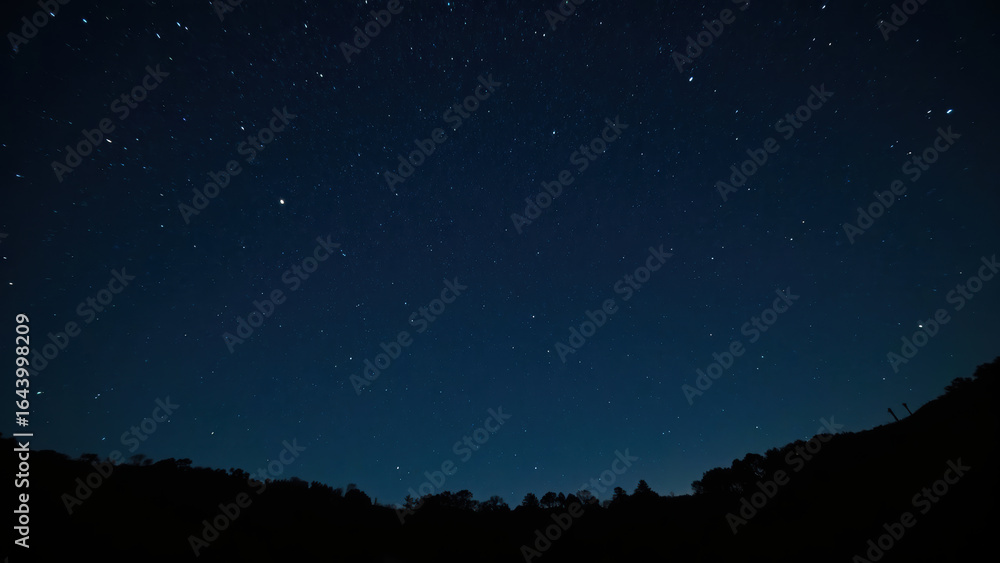 Fototapeta premium Serene night sky filled with countless stars, creating tranquil atmosphere. dark blue backdrop enhances beauty of celestial bodies
