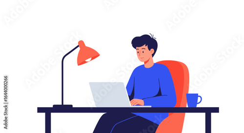 Young man working on laptop at desk with lamp and coffee cup