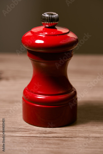Elegant Red Pepper Mill on Wooden Table – Culinary Still Life Photography