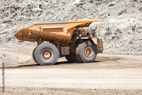 Foto A massive mining truck transports material at a large copper mine in Chile, dwarfed by the mountainous and industrial backdrop