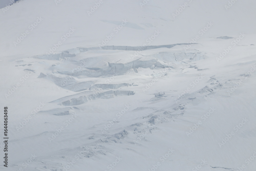 Obraz premium Elbrus slopes covered with ice and snow on a summer day in early August
