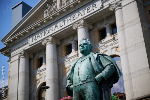 Statue of Bjørnstjerne Bjørnson in Front of the Historic Nationaltheatret Building in Oslo, Norway with Neoclassical Architecture on a Clear Day
