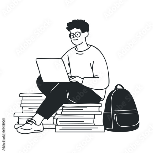 Young male student studying with laptop and books