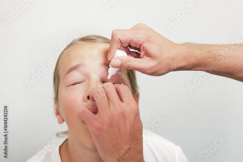 Fotografía Doctor administering eye drops to a child in an ophthalmology clinic for pupil dilation or eye treatment