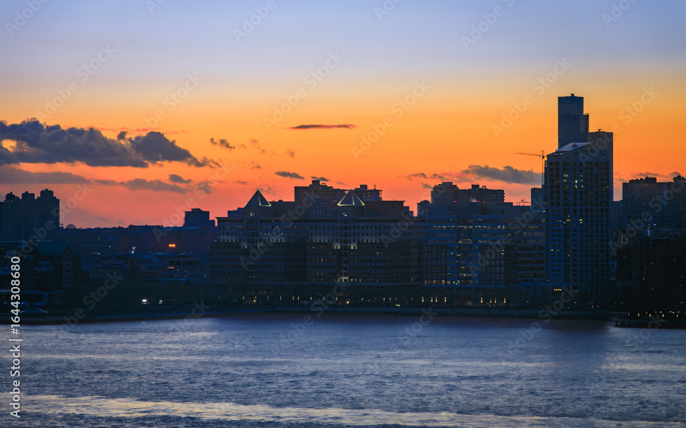 Fototapeta premium Jersey City skyline silhouette from New York, dramatic sunset over Hudson River