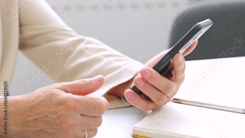 Retired woman connecting with family online using smartphone.