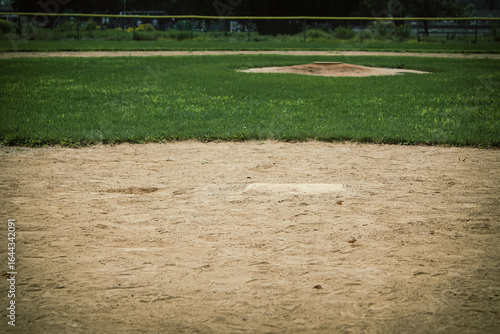 Bild auf Leinwand A baseball or softball field from a low angle view with the pitcher's mound in the distance