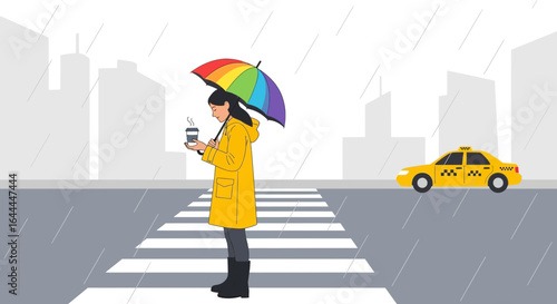 Woman holding coffee cup and looking at cellphone while crossing street in city on rainy day