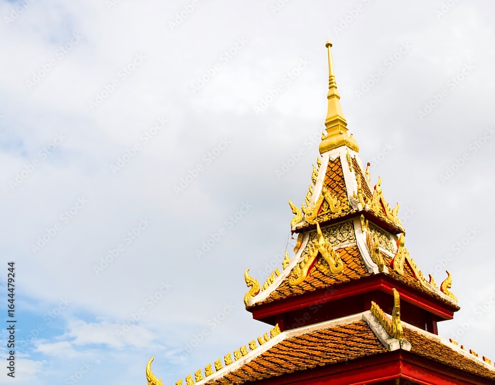 Fototapeta premium Golden roofed temple spire against cloudy sky