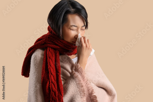 Ill Asian woman with tissue...