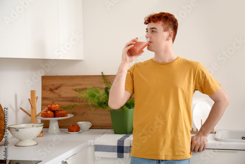 Young redhead man drinking ...