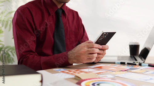 A man is working on a mobile user interface design project. He is focused on the task at hand and appears to be in a creative mood.

