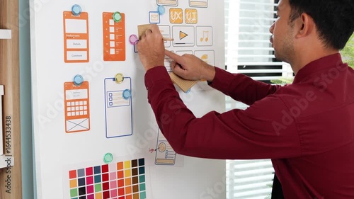 A man is working on a mobile user interface design project. He is focused on the task at hand and appears to be in a creative mood.

