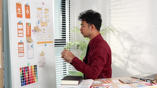 A man is working on a mobile user interface design project. He is focused on the task at hand and appears to be in a creative mood.

