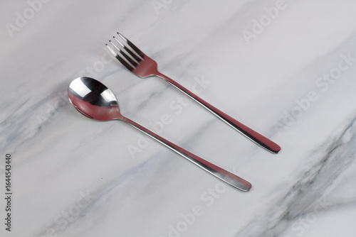 Metal spoons and forks on a marble table. Asian tableware.