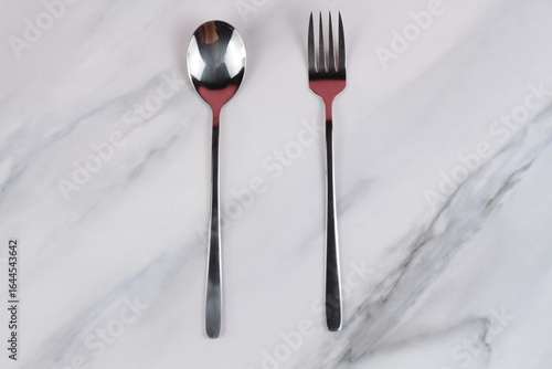 Metal spoons and forks on a marble table. Asian tableware.