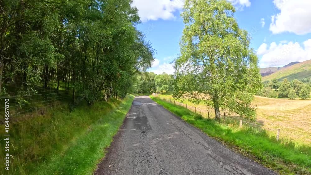 Driving Along a Rural Road Through Grassy Scottish Hills Driving Along a Rural Road Through Grassy Scottish Hills