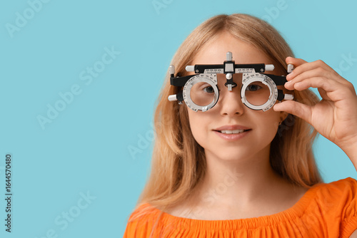 Teenage girl in trial frame on blue background, closeup. Children's Eye Healt...