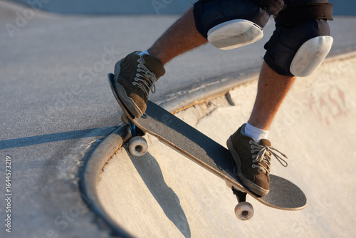 Fototapeta Close-up of skateboarder performing trick with protective gear