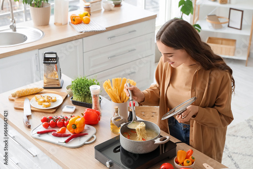 Young woman making noodle s...