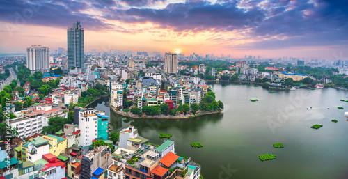 Fototapeta Naklejka Na Ścianę i Meble -  Aerial view of road crossing the island Westlake, Hanoi, Vietnam with green tree lined street, temple located between small oasis. A beautiful sunset in capital of Vietnam