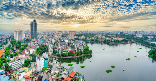 Fototapeta Naklejka Na Ścianę i Meble -  Aerial view of road crossing the island Westlake, Hanoi, Vietnam with green tree lined street, temple located between small oasis. A beautiful sunset in capital of Vietnam