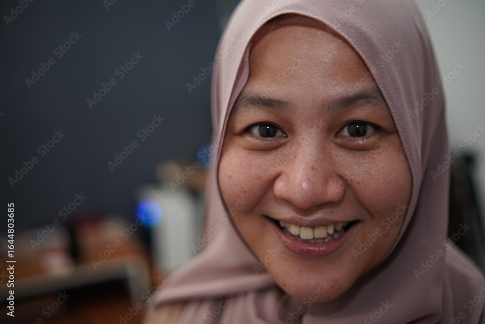 Happy confident Asian muslim woman smiling at camera, successful entrepreneur, close up portrait