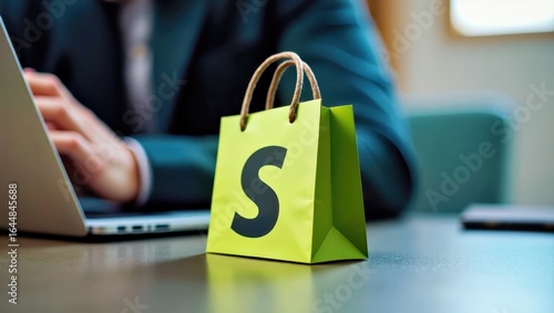 Shopify Developer. Green shopping bag with Shopify logo on office desk