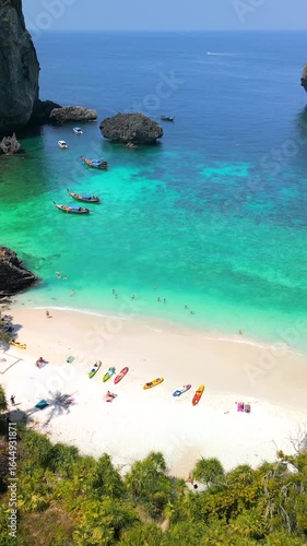 Aerial view of tropical beach and turquoise sea at Phi Phi Islands, Thailand, with white sand, limestone cliffs, and boats in scenic paradise.