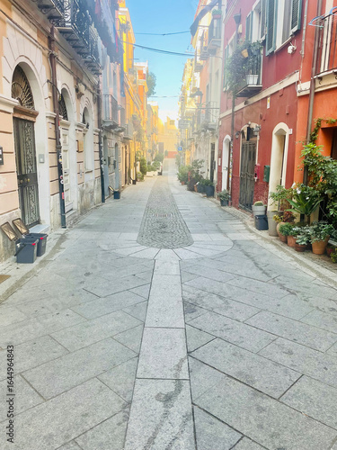 Picturesque narrow alleyways in the historic center of Cagliari, Sardinia, Italy. Colorful old buildings with balconies and flowers, cobblestone streets