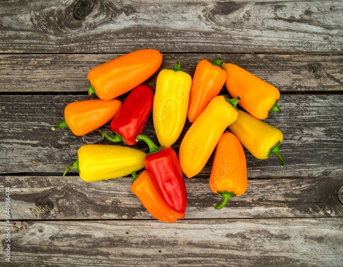 Colorful mini sweet peppers arranged on weathered wood