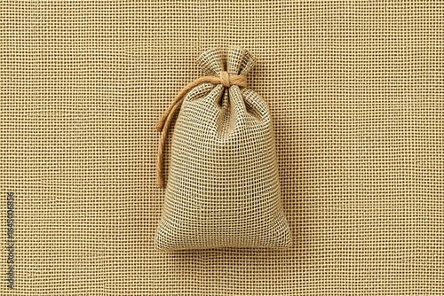 Small drawstring pouch filled with dried herbs or spices on a textured background