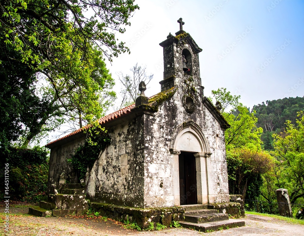 Fototapeta premium Aged stone chapel nestled in a verdant forest